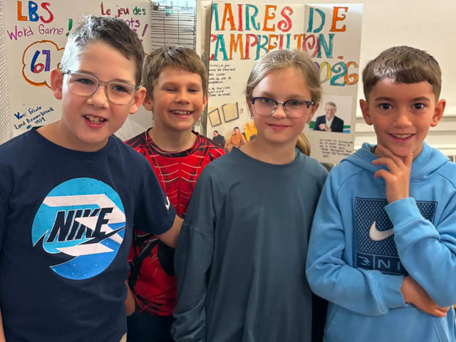 Four students standing in front of displays