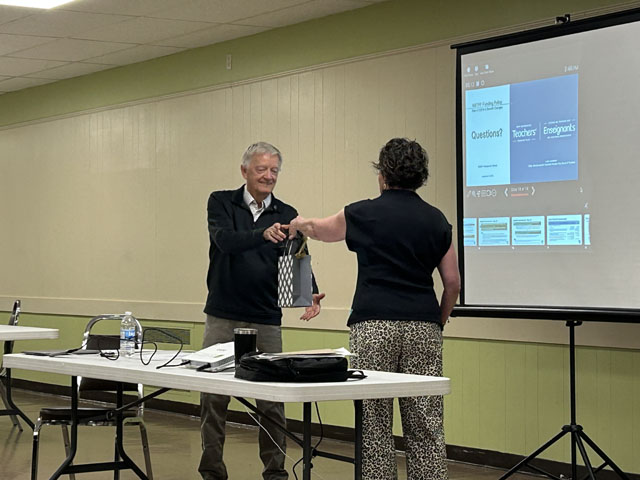 A speaker being handed a gift 